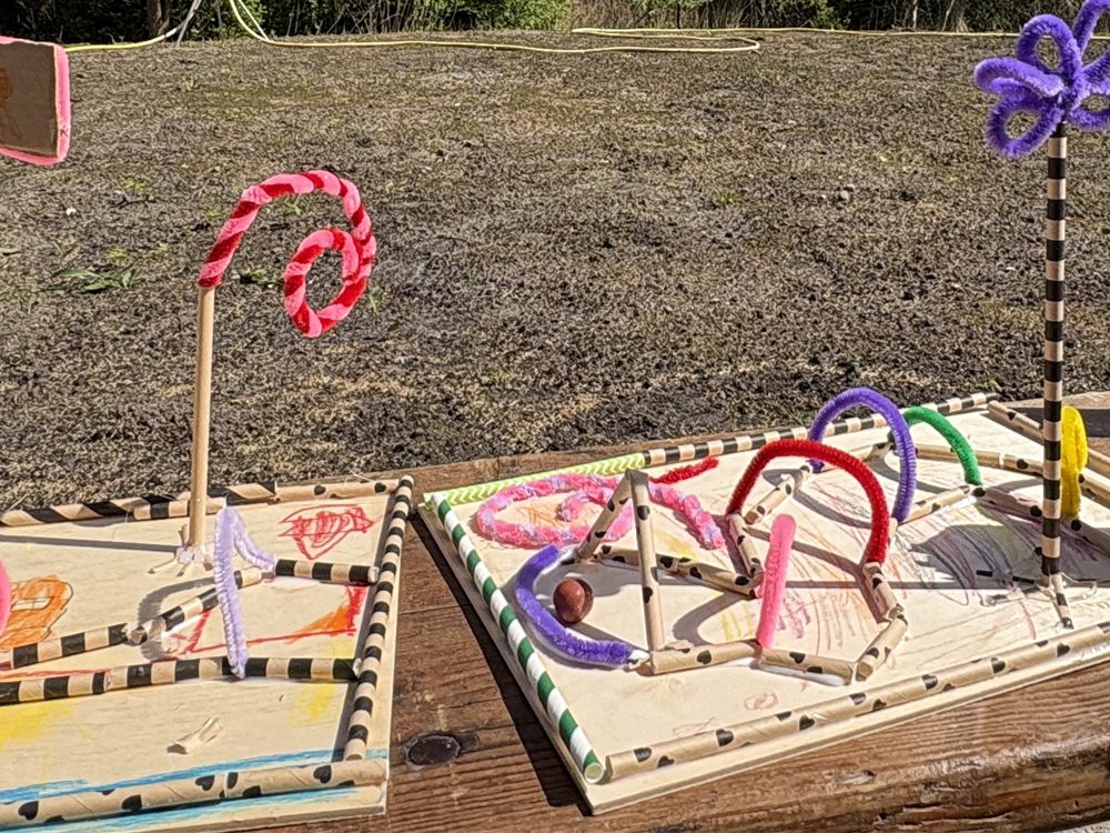 Selbst gebaute Murmellabyrinthe aus Pappstrohhalmen und Pfeifenputzern auf Holzbrettern